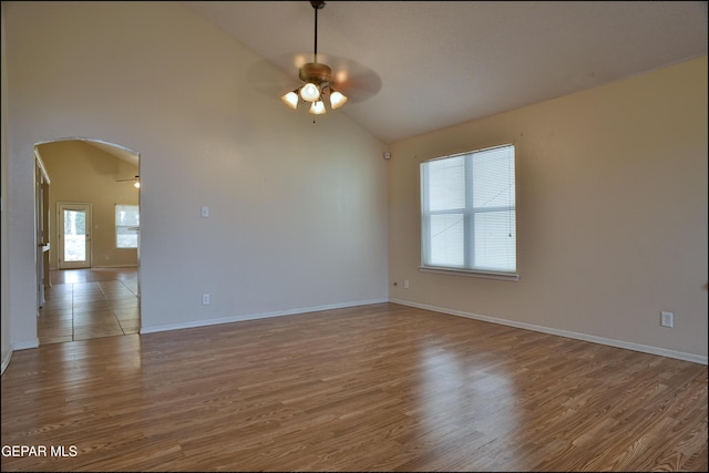 spare room featuring ceiling fan, light wood-type flooring, and high vaulted ceiling