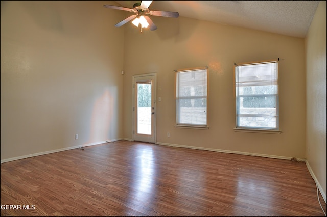 unfurnished room with hardwood / wood-style floors, ceiling fan, a textured ceiling, and high vaulted ceiling