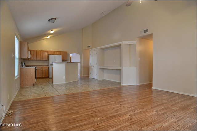 kitchen featuring white appliances, high vaulted ceiling, and light hardwood / wood-style flooring