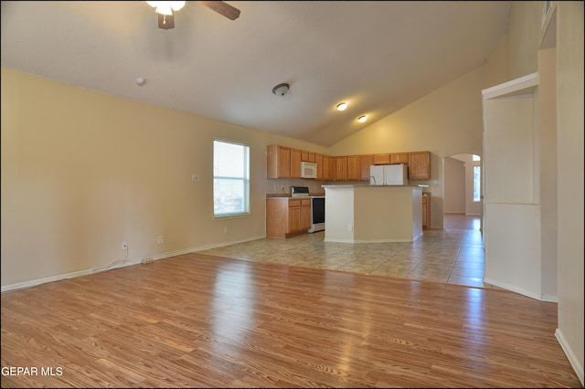 unfurnished living room with ceiling fan, high vaulted ceiling, and light hardwood / wood-style flooring