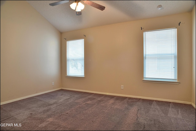 carpeted empty room featuring a textured ceiling, vaulted ceiling, and ceiling fan