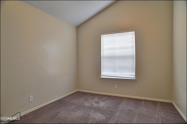 spare room with carpet flooring, a textured ceiling, and lofted ceiling