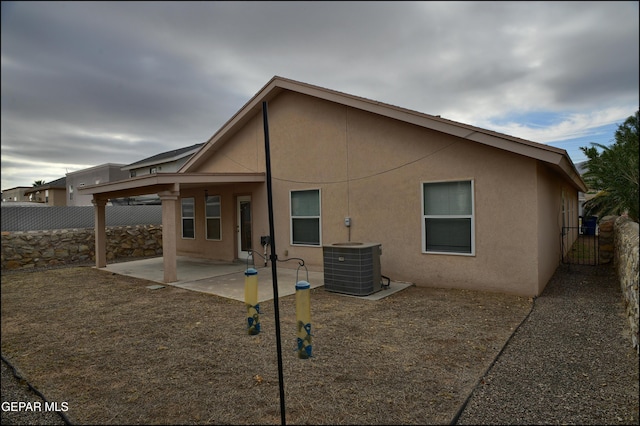 back of property with cooling unit and a patio