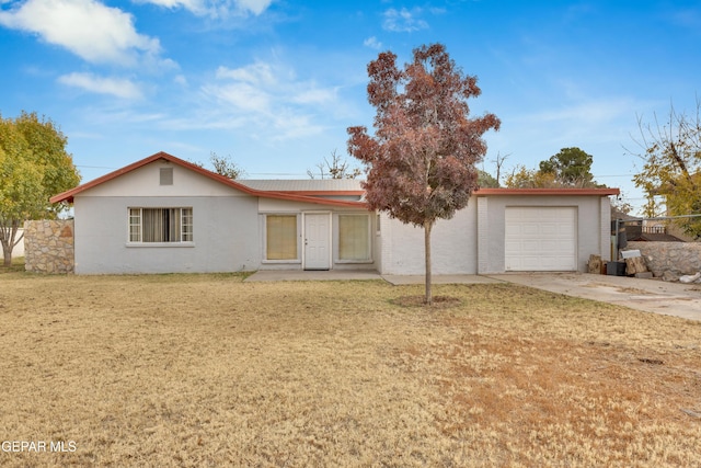 ranch-style home featuring a garage and a front lawn