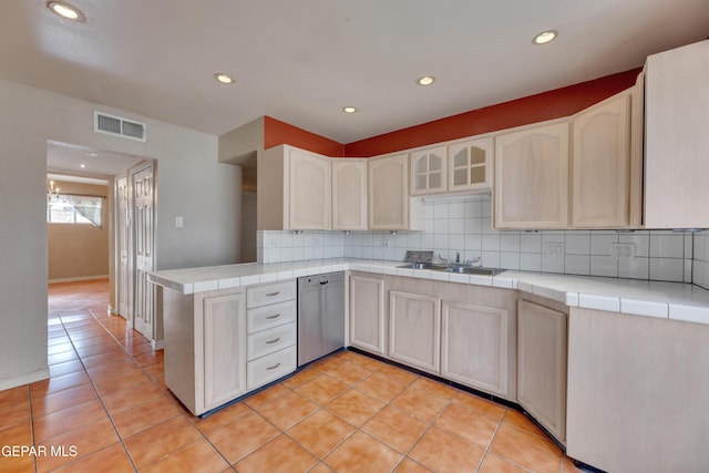 kitchen with dishwasher, light tile patterned floors, and tile counters