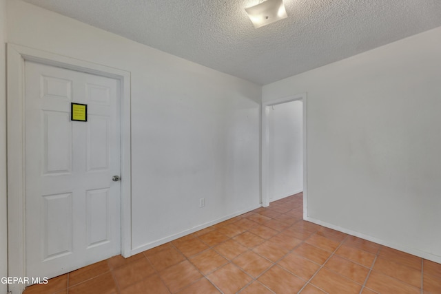 tiled spare room with a textured ceiling