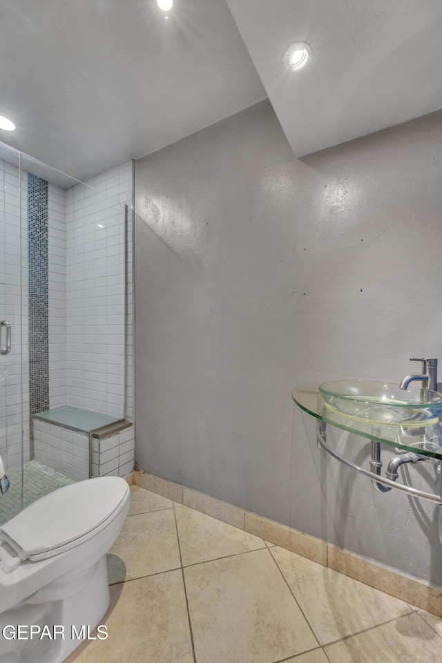 bathroom with tile patterned floors, sink, walk in shower, and toilet