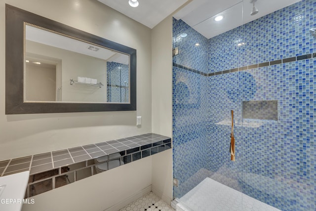 bathroom featuring tiled shower and tile patterned flooring