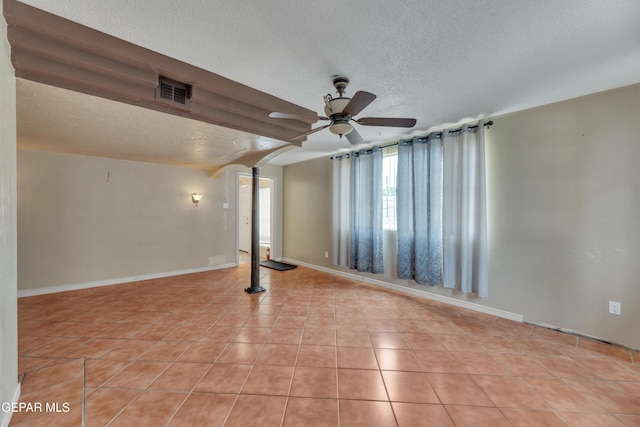 tiled spare room featuring ceiling fan and a textured ceiling