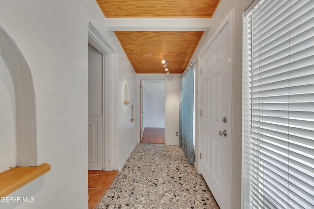 hall with light tile patterned floors and wood ceiling