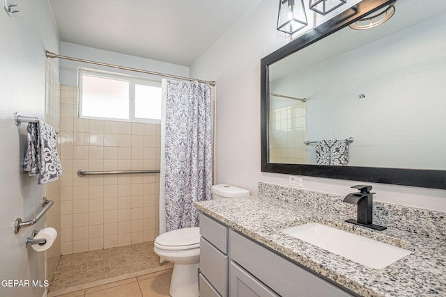 bathroom featuring tiled shower, vanity, toilet, and tile patterned floors