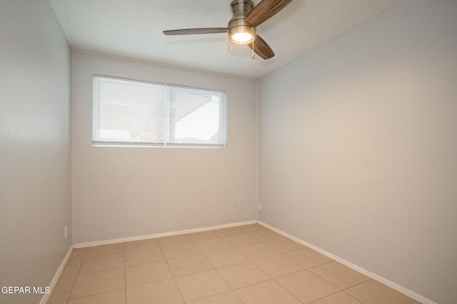 empty room featuring ceiling fan and baseboards