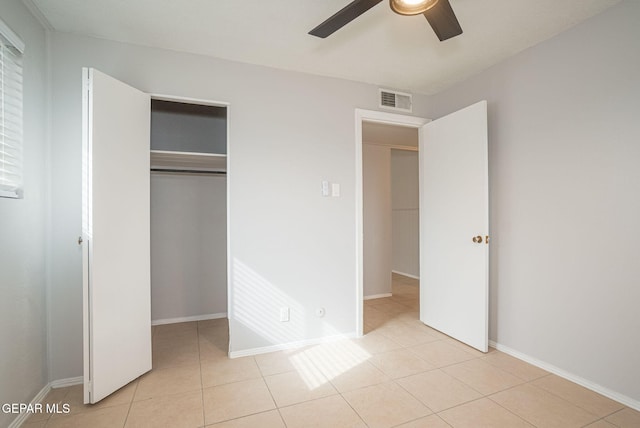 unfurnished bedroom featuring a closet, visible vents, baseboards, and light tile patterned flooring