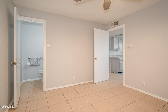 unfurnished bedroom featuring light tile patterned flooring, visible vents, and baseboards