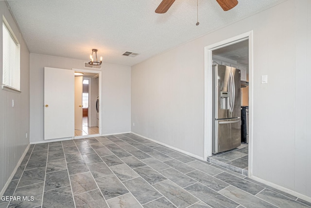 spare room featuring plenty of natural light, visible vents, and a textured ceiling