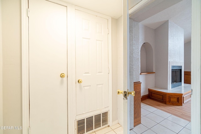 hallway featuring visible vents and light tile patterned floors