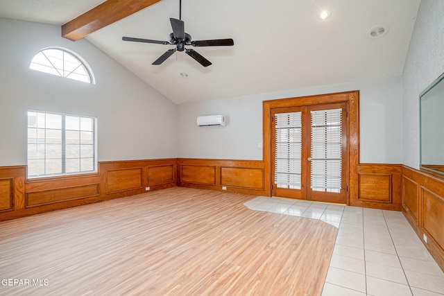 unfurnished room with a wainscoted wall, vaulted ceiling with beams, french doors, light wood-style floors, and a wall mounted AC