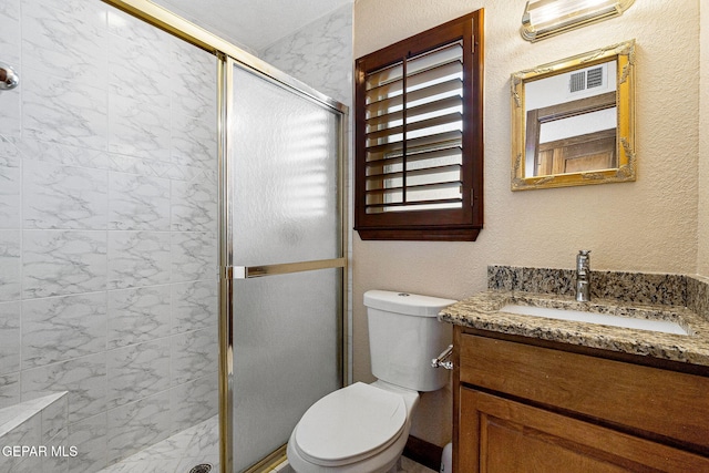 bathroom featuring an enclosed shower, vanity, and toilet