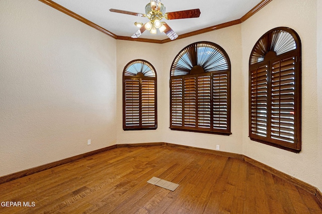 empty room with hardwood / wood-style floors, ceiling fan, and crown molding