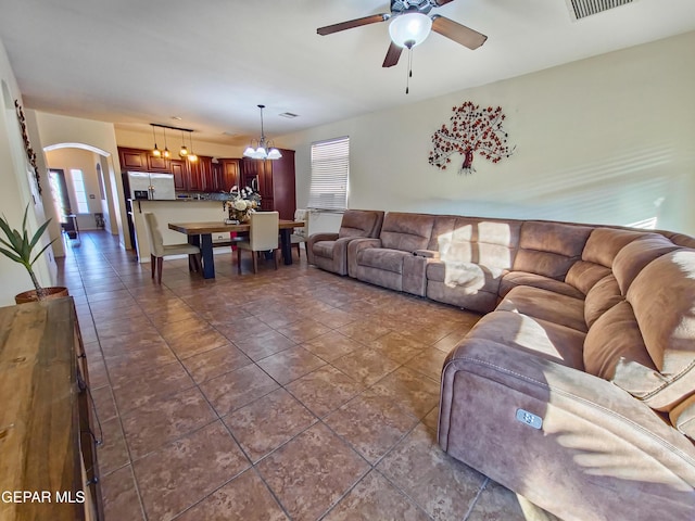 12298 Stansbury Dr, El Paso, TX 79928 - tiled living room with ceiling fan with notable chandelier