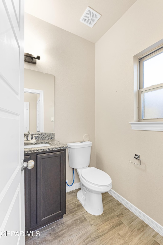 bathroom with vanity, hardwood / wood-style flooring, and toilet