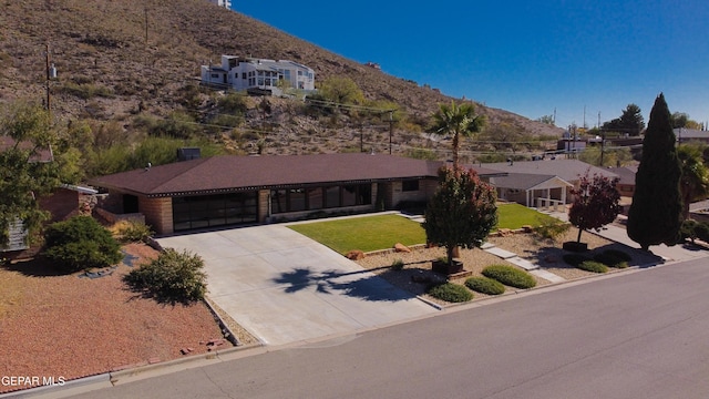 view of front facade with a mountain view, a garage, and a front lawn