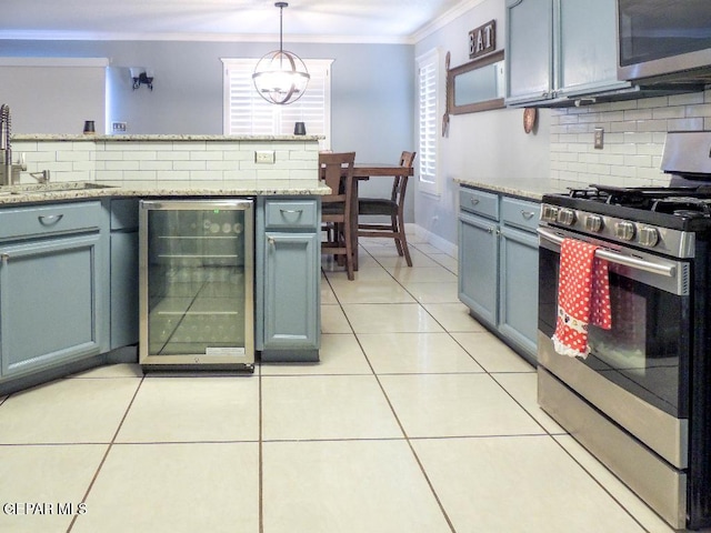 kitchen featuring decorative backsplash, stainless steel appliances, sink, pendant lighting, and wine cooler