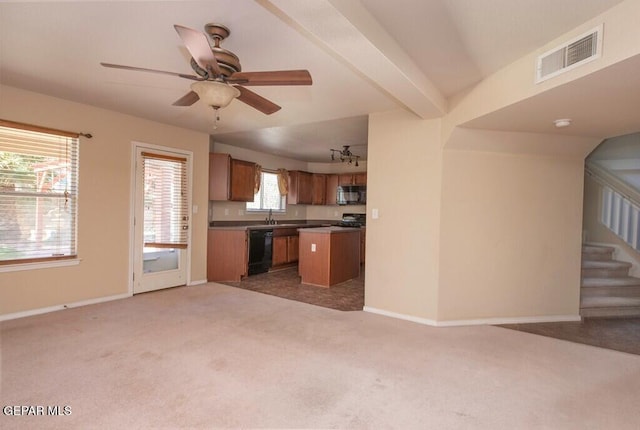 kitchen featuring beam ceiling, ceiling fan, a center island, carpet floors, and black appliances