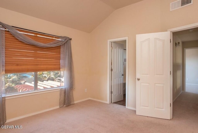 unfurnished bedroom with light carpet and vaulted ceiling