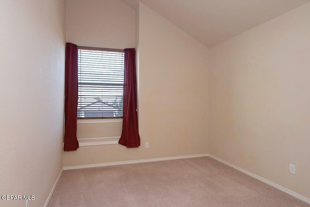 spare room with light carpet and lofted ceiling