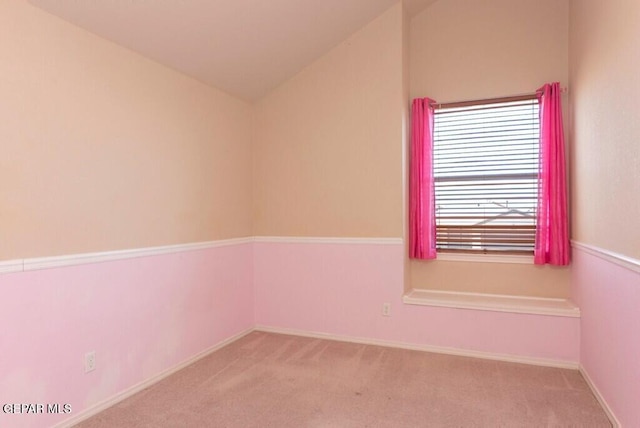 unfurnished room featuring light carpet and vaulted ceiling