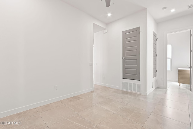 tiled spare room with ceiling fan