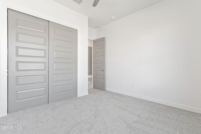 unfurnished bedroom with light carpet, a closet, and ceiling fan