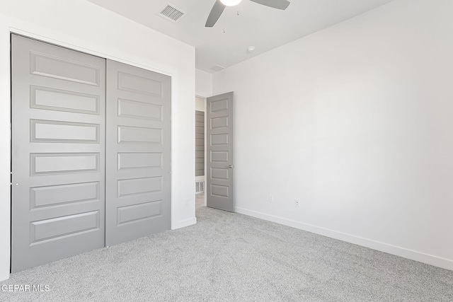 unfurnished bedroom with ceiling fan, a closet, and light colored carpet