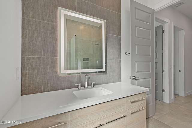 bathroom featuring tile patterned flooring, vanity, and walk in shower