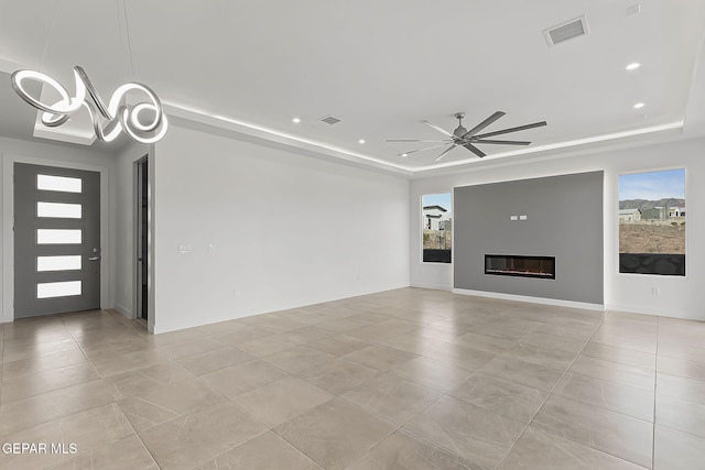 unfurnished living room featuring light tile patterned floors, a tray ceiling, and ceiling fan