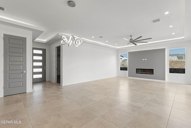 unfurnished living room featuring a raised ceiling, ceiling fan, and light tile patterned flooring