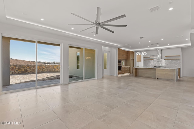 unfurnished living room with light tile patterned floors, ceiling fan, and sink