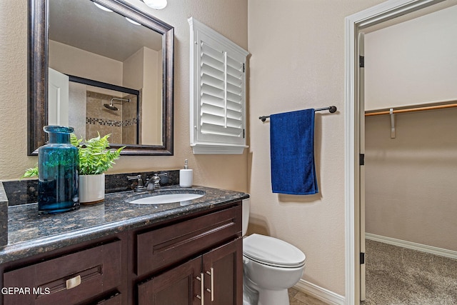 bathroom featuring vanity, toilet, and walk in shower