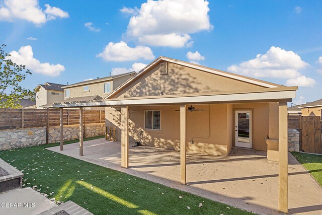 back of property with ceiling fan and a patio area