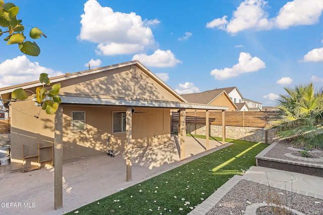 back of property with ceiling fan and a patio area