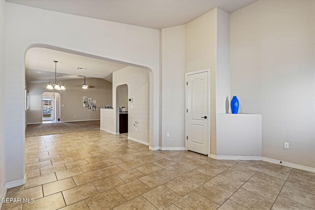 spare room featuring vaulted ceiling and a notable chandelier