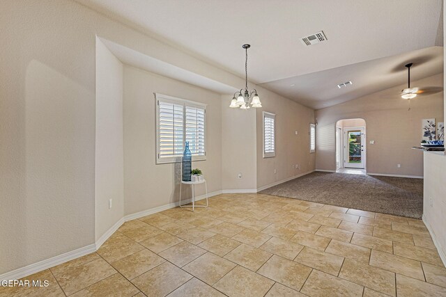 carpeted empty room with ceiling fan with notable chandelier and vaulted ceiling