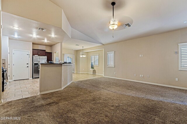 kitchen featuring a wealth of natural light, stainless steel fridge with ice dispenser, dark brown cabinets, and lofted ceiling