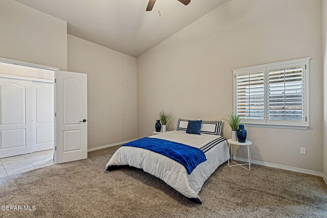 bedroom featuring ceiling fan, a closet, carpet, and vaulted ceiling