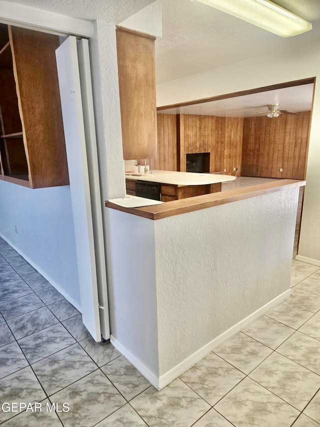 kitchen with light tile patterned floors, a textured ceiling, sink, and ceiling fan