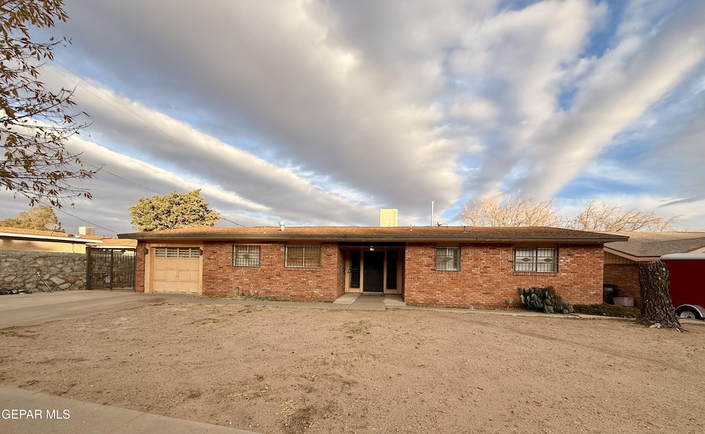 back of house featuring a garage, concrete driveway, and brick siding