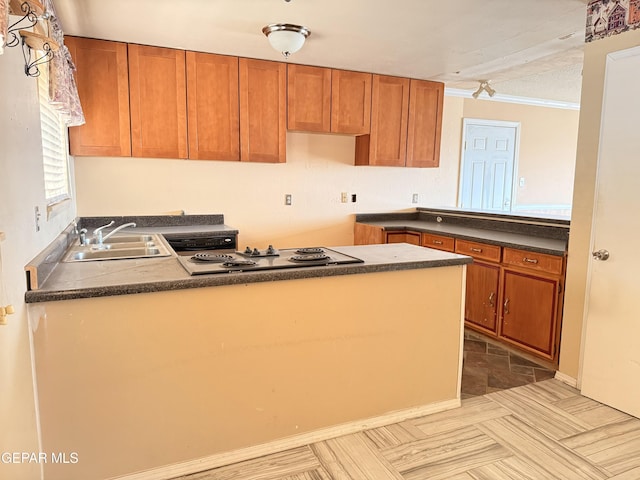 kitchen featuring dark countertops, ornamental molding, a sink, electric stovetop, and a peninsula