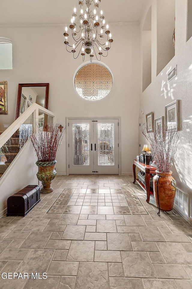 entrance foyer with french doors, a high ceiling, and an inviting chandelier