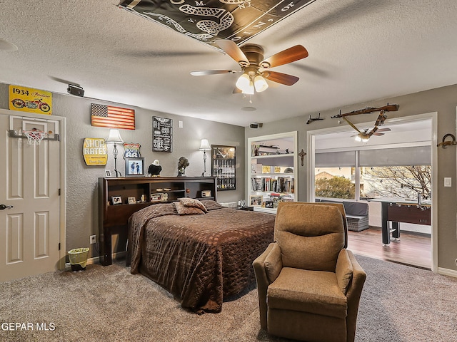 carpeted bedroom with ceiling fan and a textured ceiling